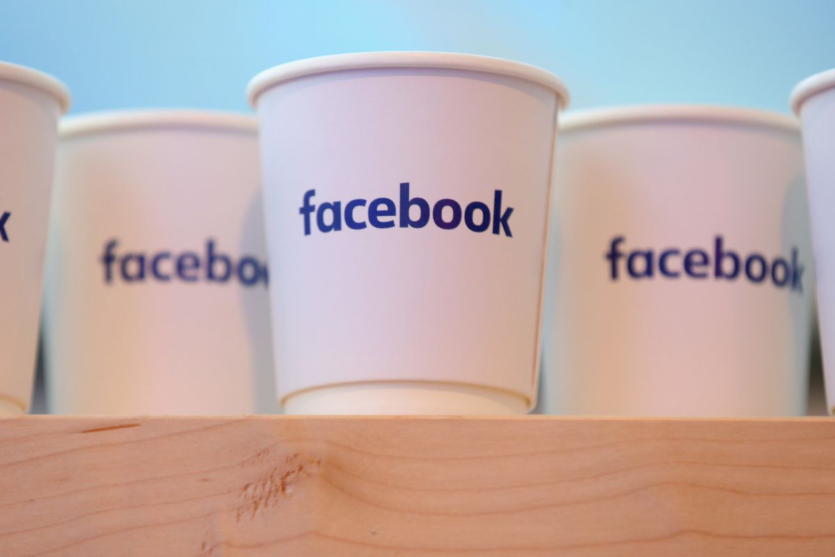 Facebook logo on white paper coffee cups