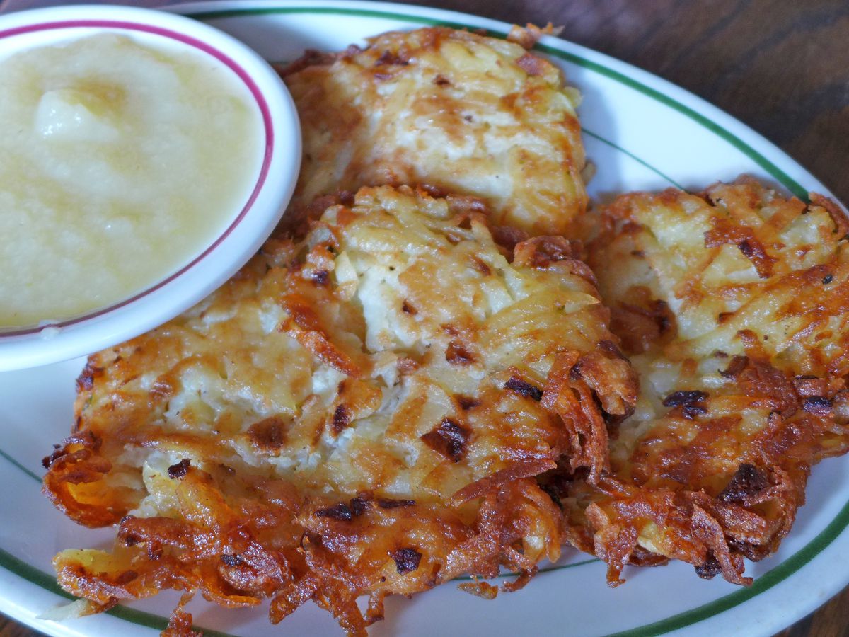 A pair of pancakes made of shredded potatoes and chopped onions.