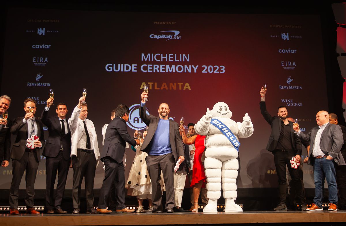 Atlanta’s five one-star restaurants raiser their champagne glass in celebration on stage at the Michelin guide ceremony with the Michelin Man giving two thumbs up. 