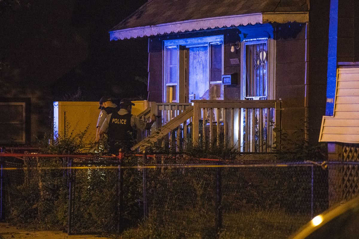 Police investigate the scene where two girls, 11 and 17, were shot Sunday night in the 11700 block of South Perry Street. | Tyler LaRiviere/Sun-Times