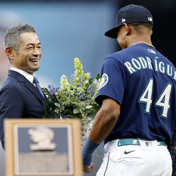 SEATTLE, WASHINGTON - AUGUST 27: Former Seattle Mariner Ichiro Suzuki receives flowers from Julio Rodriguez #44 of the Seattle Mariners during the Mariners Hall of Fame pregame ceremony prior to the game between the Cleveland Guardians and the Seattle Mariners at T-Mobile Park on August 27, 2022 in Seattle, Washington