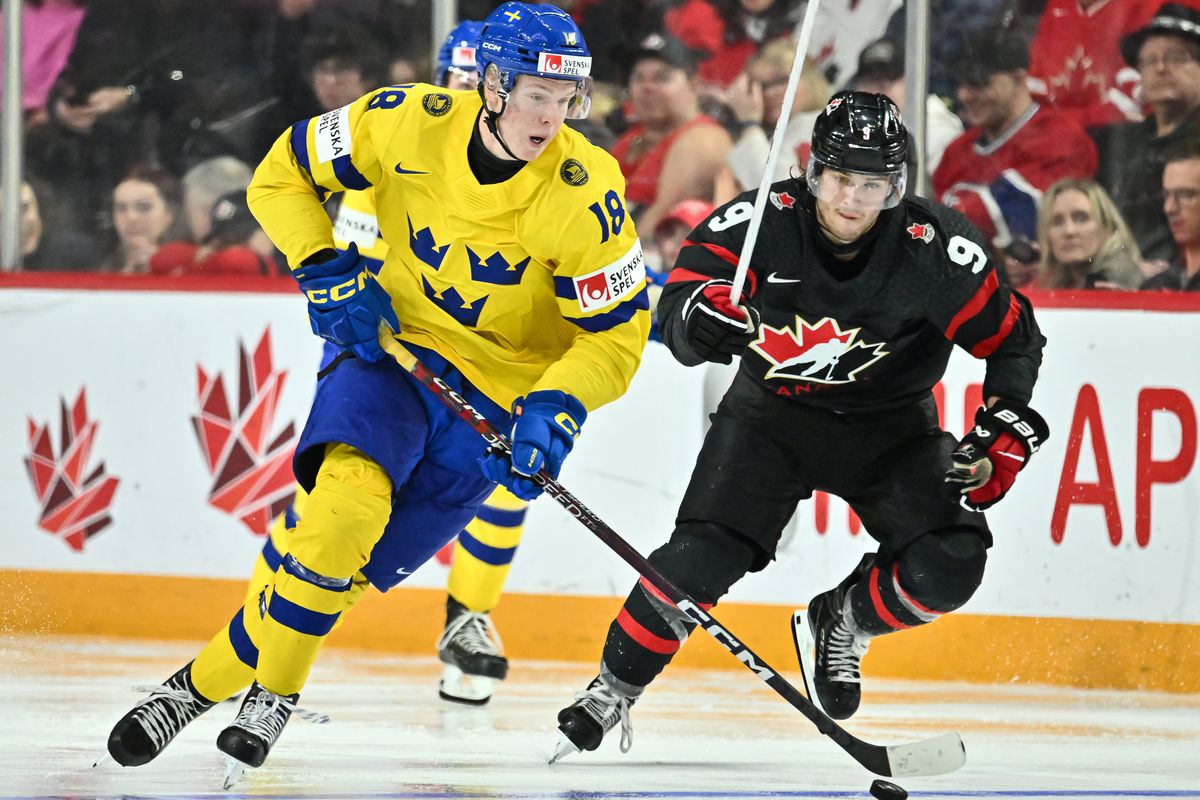 Filip Bystedt #18 of Team Sweden skates the puck against Joshua Roy #9 of Team Canada during the third period in the 2023 IIHF World Junior Championship at Scotiabank Centre on December 31, 2022 in Halifax, Nova Scotia, Canada. Team Canada defeated Team Sweden 5-1.