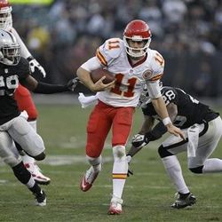 Kansas City Chiefs quarterback Alex Smith (11) runs against Oakland Raiders cornerback Brandian Ross (29) and defensive back Phillip Adams (28) during the fourth quarter of an NFL football game in Oakland, Calif., Sunday, Dec. 15, 2013. 