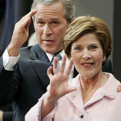 In this Nov. 3, 2004, file photo, President George W. Bush and first lady Laura Bush salute and wave during an election victory rally at the Ronald Reagan Building and International Trade Center in Washington.