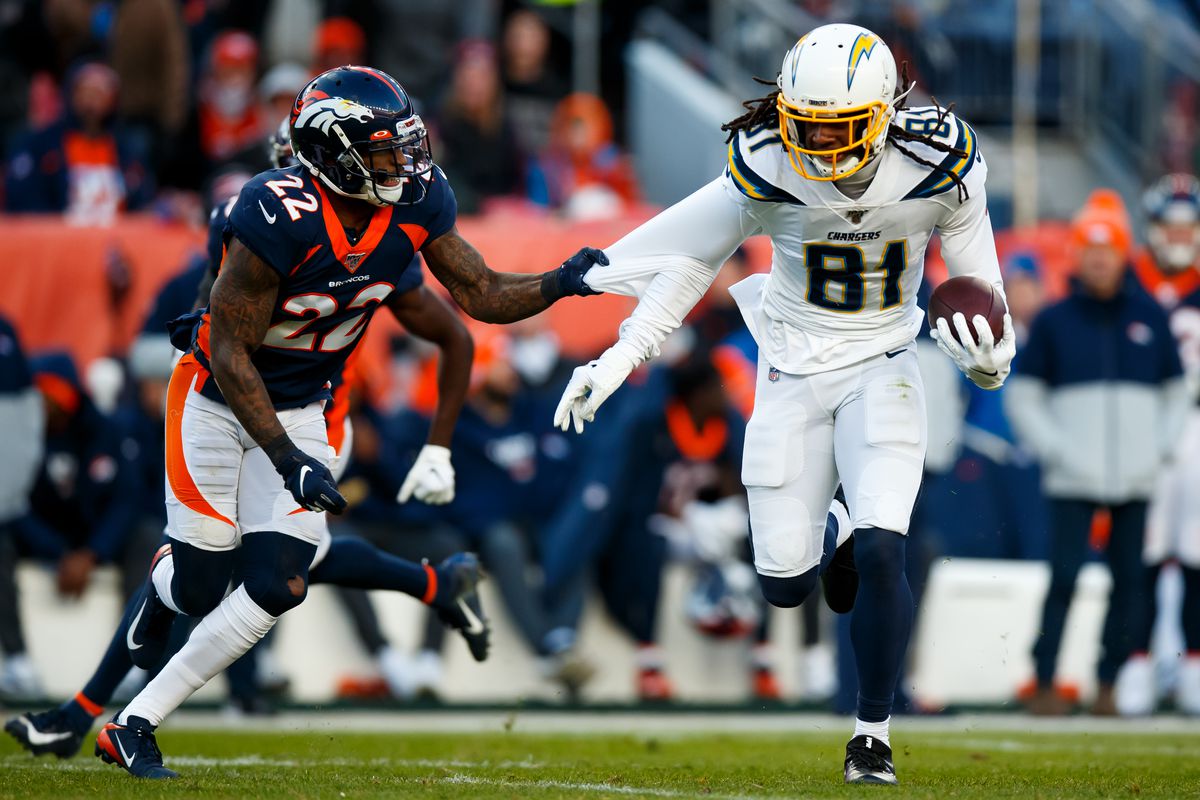 Wide receiver Mike Williams #81 of the Los Angeles Chargers tries to elude cornerback Kareem Jackson #22 of the Denver Broncos after catching a pass during the second quarter at Empower Field at Mile High on December 1, 2019 in Denver, Colorado.