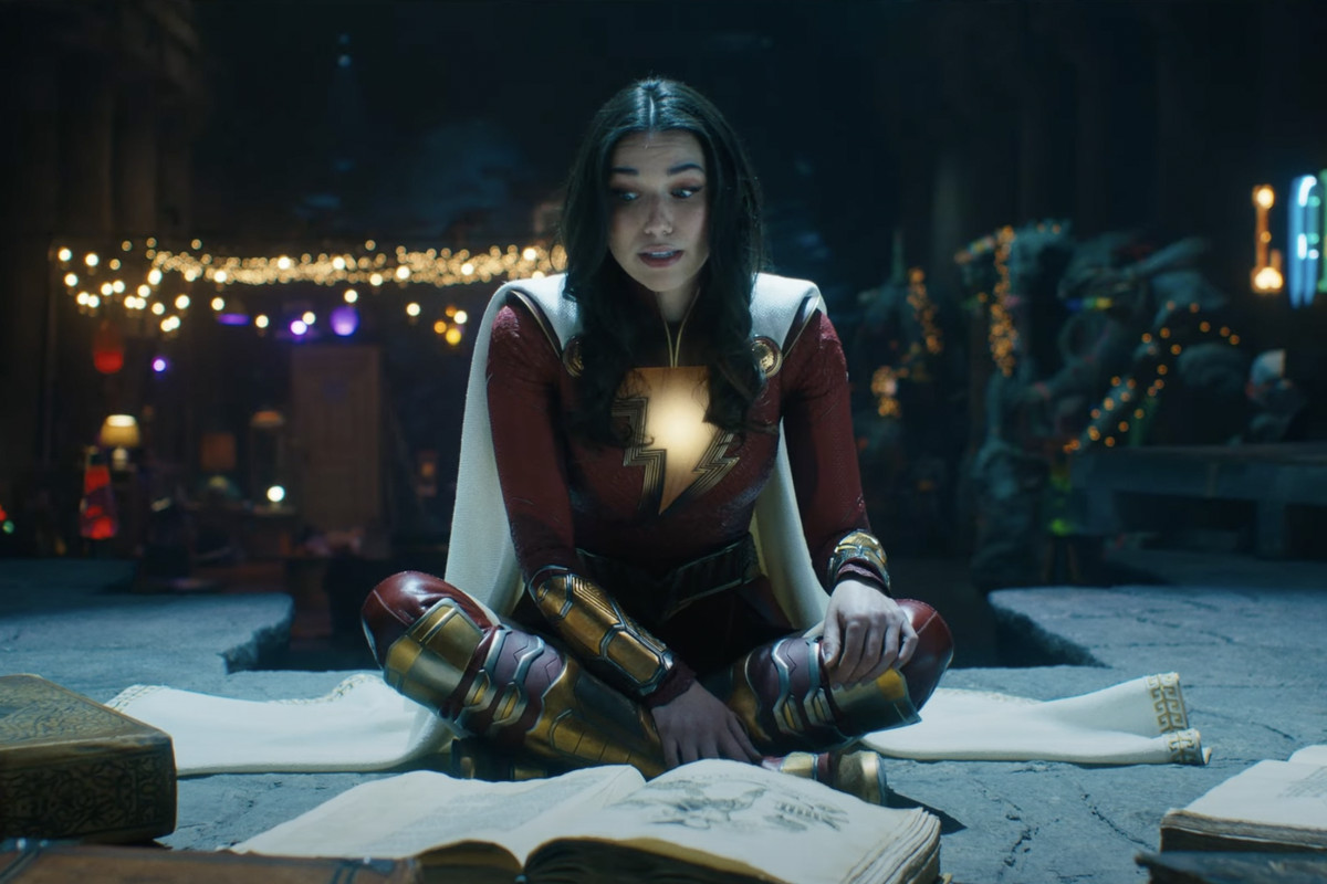 Mary in Shazam Fury of the Gods sits with books spread around her, her face a bit panicked