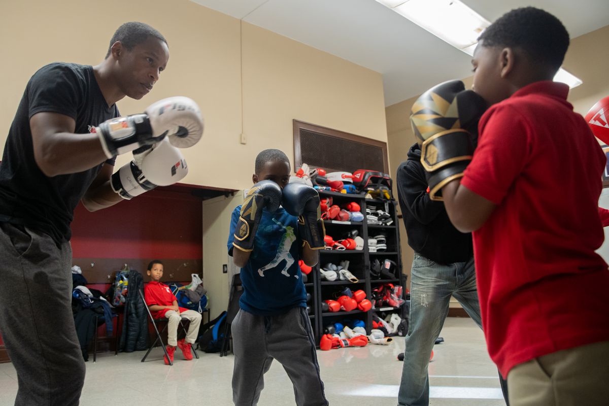 Executive director and founder of The Bloc, Jamyle Cannon (left) works with students during an after school boxing class at Frazier Prepatory Academy.