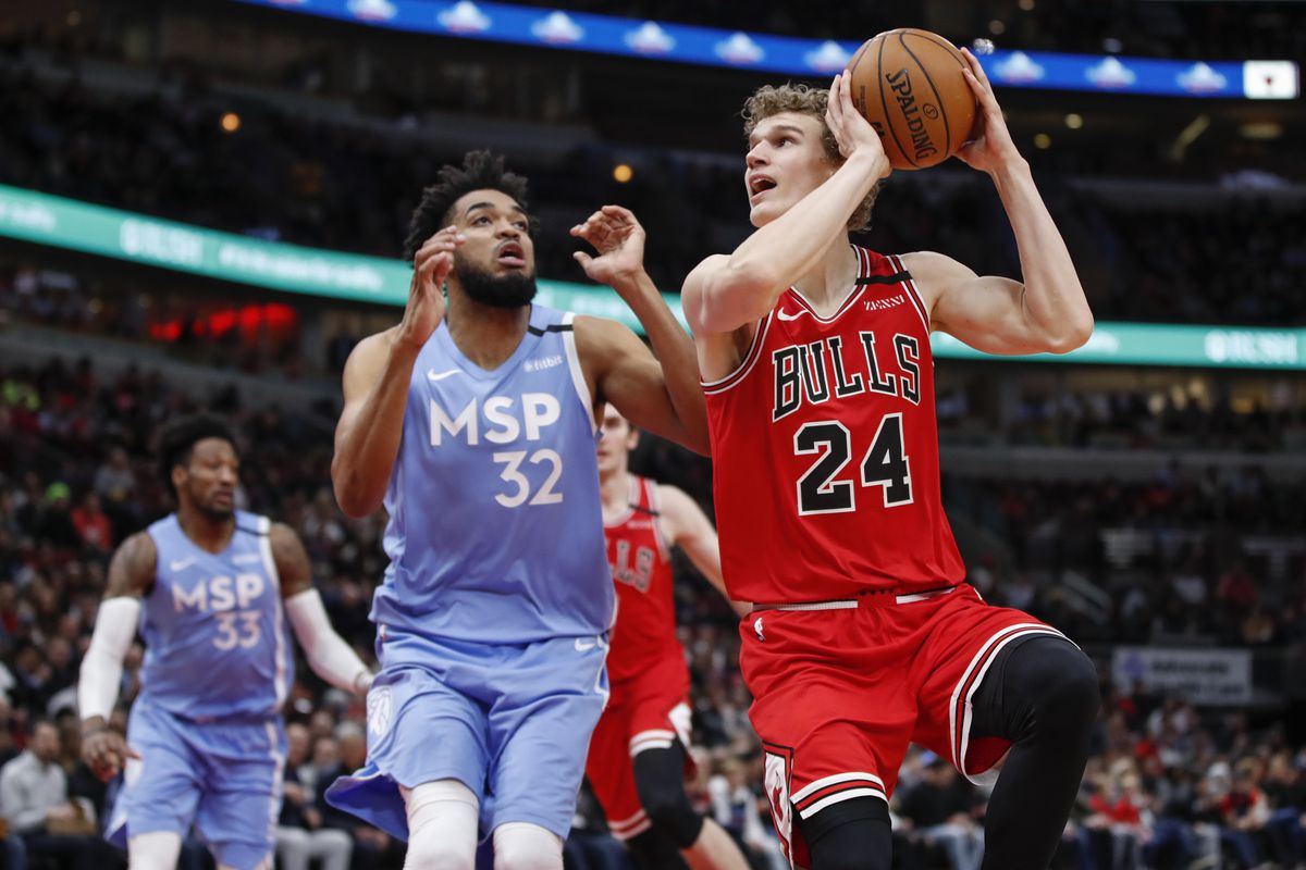 Chicago Bulls forward Lauri Markkanen shoots against Minnesota Timberwolves center Karl-Anthony Towns during the first half at United Center.