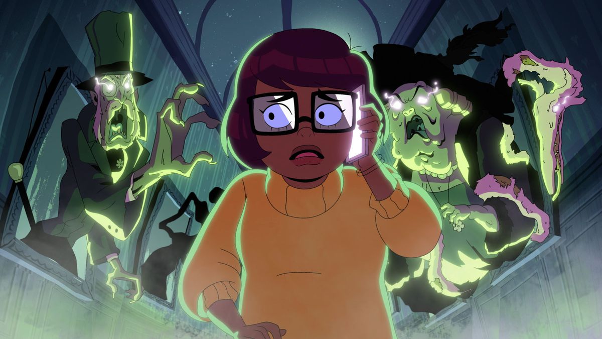 Velma (voiced by Mindy Kaling) looks scared of green ghosts behind her