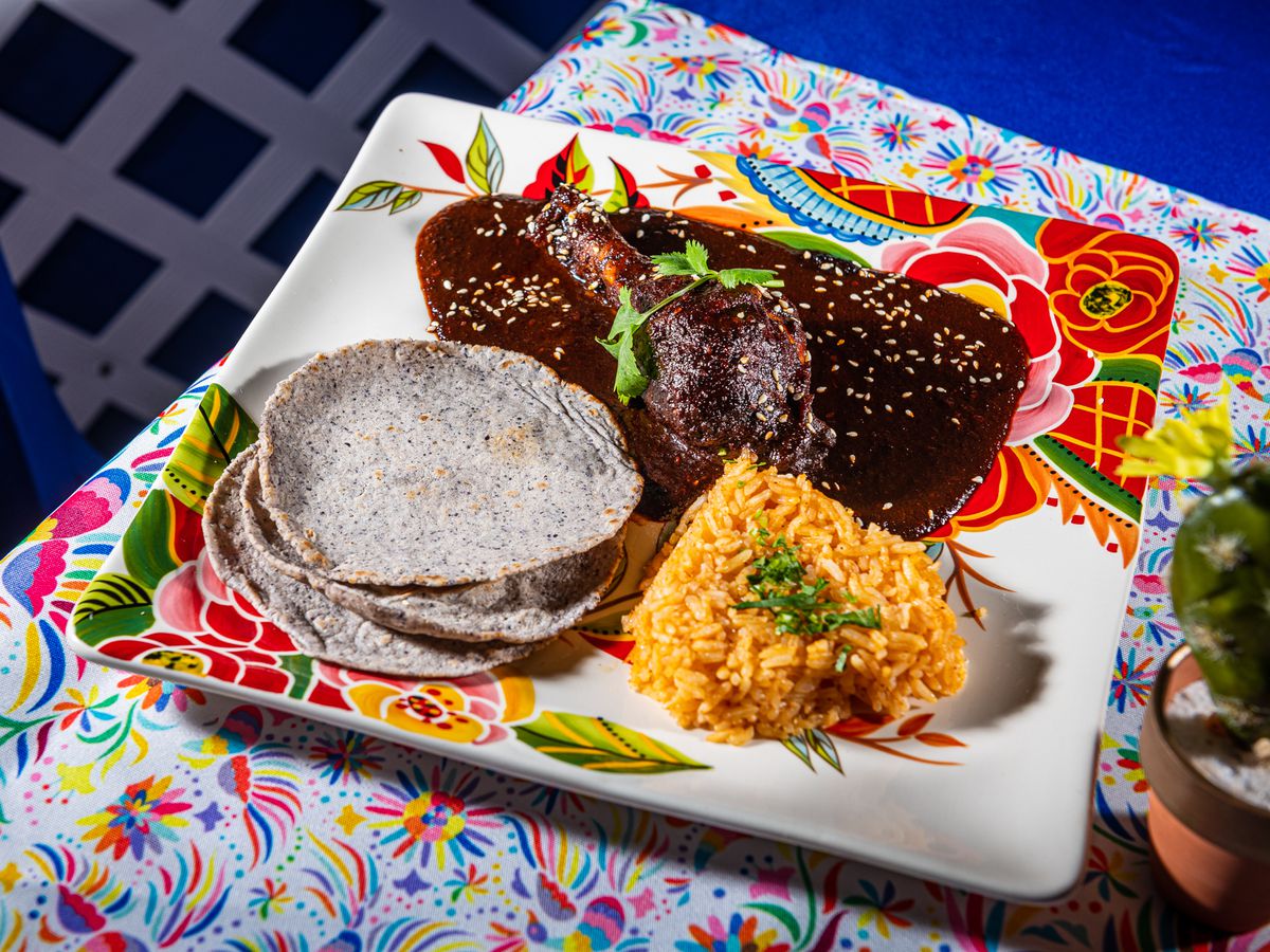 Pollo con Mole (chicken topped with red mole, served with rice and fresh tortillas) from Corazon.
