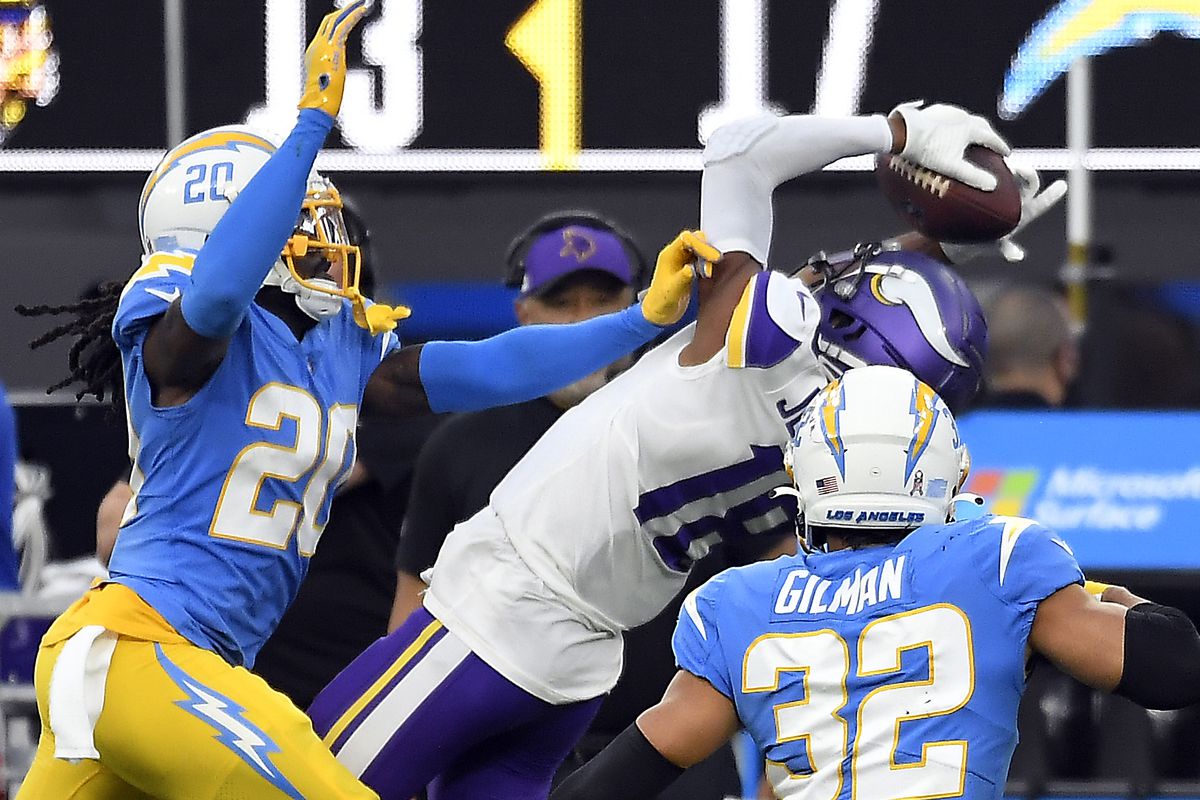 Justin Jefferson #18 of the Minnesota Vikings makes a catch for a first down as Tevaughn Campbell #20 and Alohi Gilman #32 of the Los Angeles Chargers defend during the second half of the game at SoFi Stadium on November 14, 2021 in Inglewood, California.