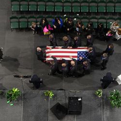 Family members stand next to West Valley City police officer Cody Brotherson's casket as they prepare to exit the Maverik Center following Brotherson's funeral in West Valley City on Monday, Nov. 14, 2016.