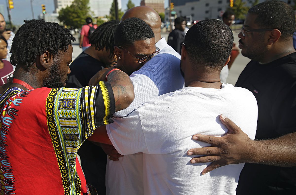 Protesters pray over Tyler Johnson, son of Terence Crutcher, in front of the Tulsa County Courthouse on Monday. | Mike Simmons/Tulsa World via AP