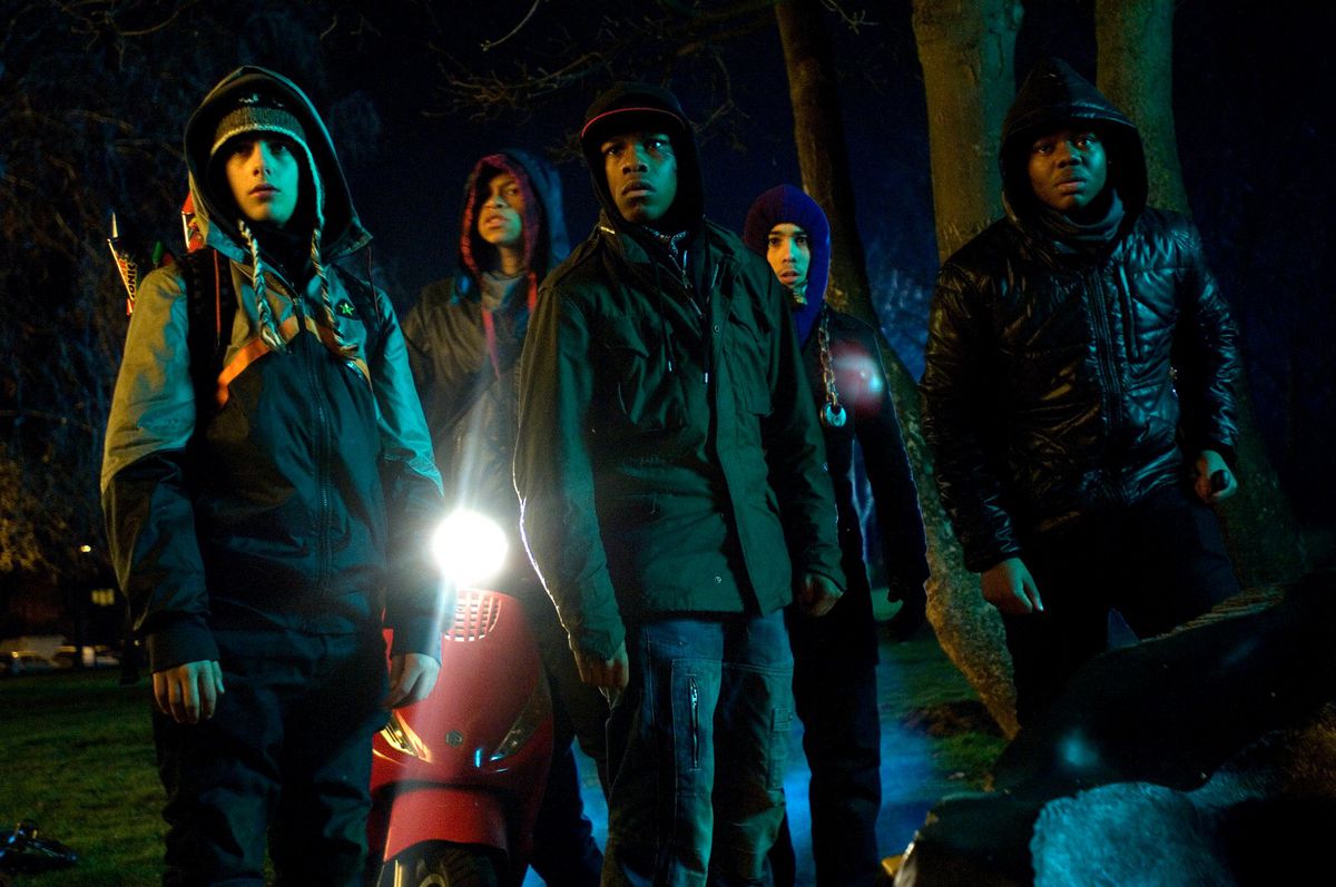The cast of Attack the Block stand in front of a motor scooter