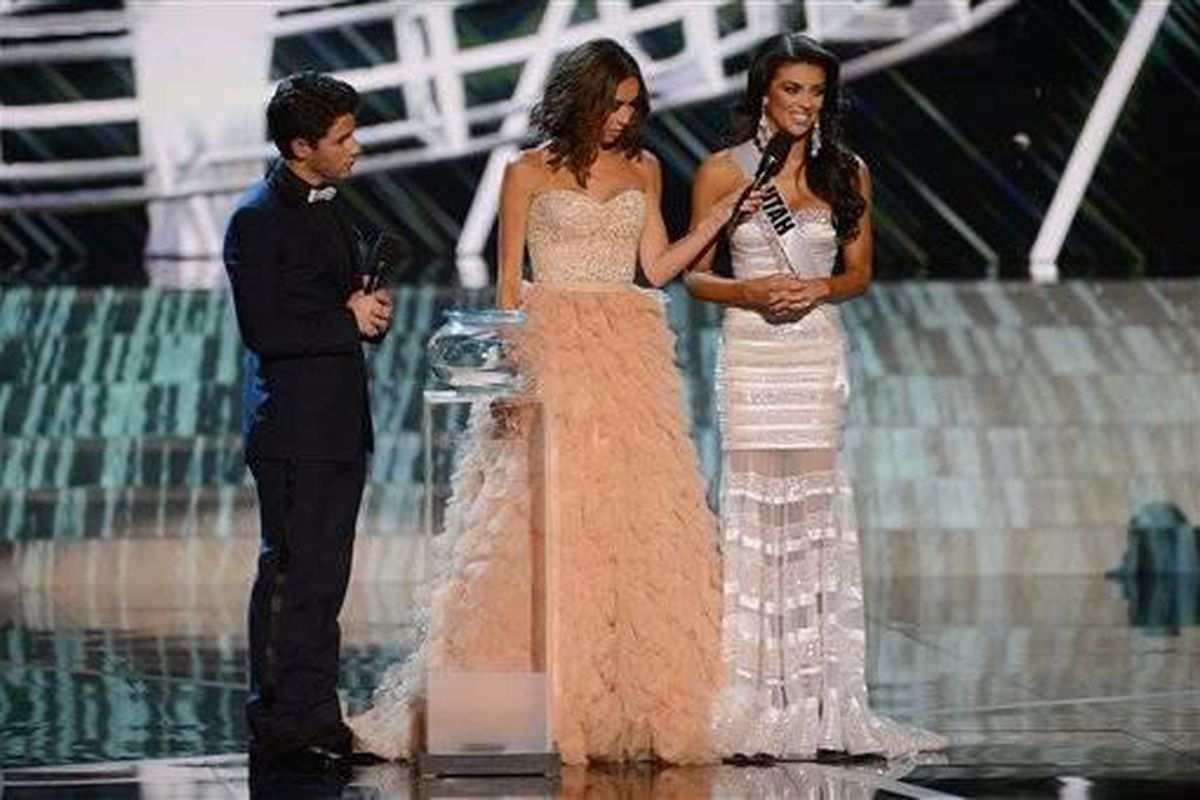 From left, recording artist and host Nick Jonas, television personality and host Giuliana Rancic look on as Miss Utah Marissa Powell answers a question from the judges during the interview portion of the Miss USA 2013 pageant, Sunday, June 16, 2013, in La