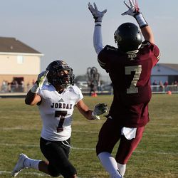 Beau Peterson of Lone Peak catches a touchdown pass with Benjamin Reyes of Jordan defending during 5A high school football action in Highland on Friday, Nov. 4, 2016.