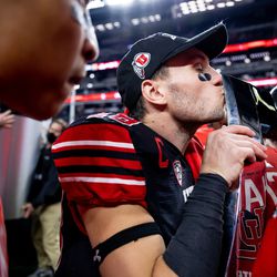 Utah Utes wide receiver Britain Covey (18) kisses the trophy after the Utes beat the Oregon Ducks in the Pac-12 championship game at Allegiant Stadium in Las Vegas on Friday, Dec. 3, 2021.