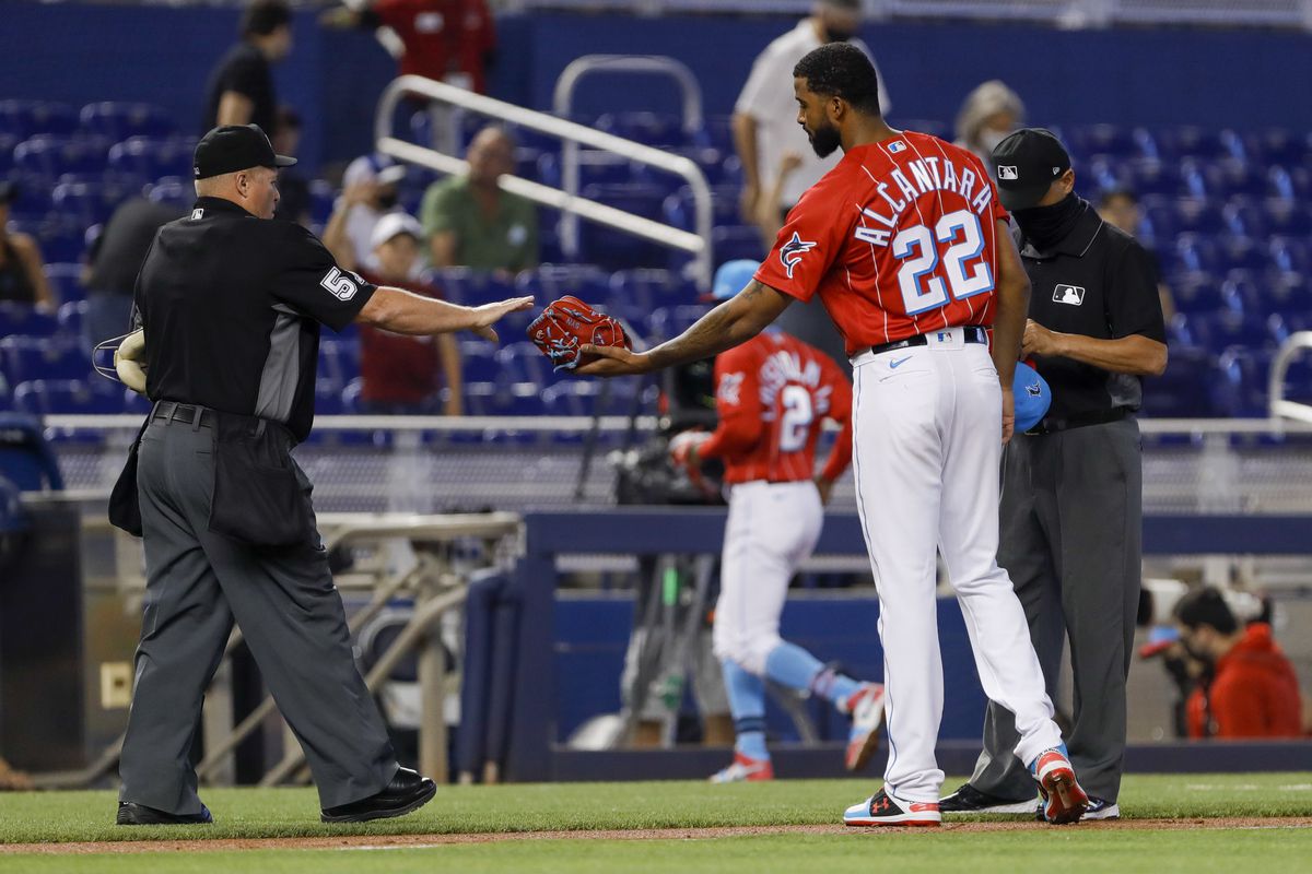 Home plate umpire Marvin Hudson (51) checks Miami Marlins starting pitcher Sandy Alcantara (22) for foreign substances after the first inning at loanDepot Park
