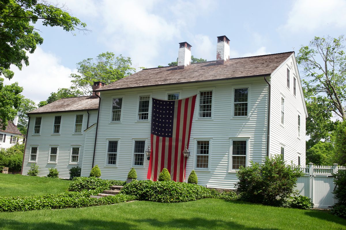 A house with a two-story-size American flag on the front.