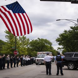 Officers salute outside the Cook County medical examiner’s office on the afternoon of Tuesday, July 28, 2020 as an ambulance passes containing the body of Deputy Chief Dion Boyd, who was found dead in his office that morning of an apparent suicide.