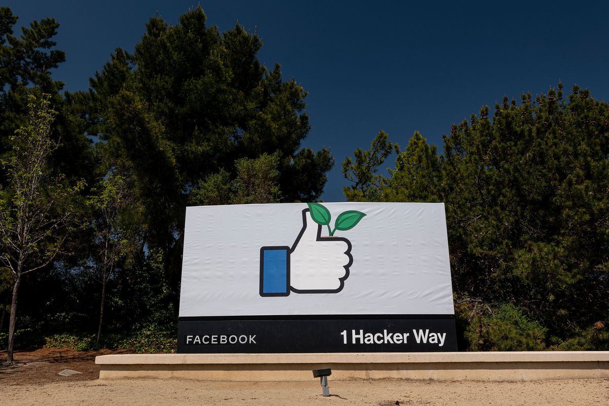 The Facebook sign at 1 Hacker Way shows a thumbs-up icon holding a plant sprout.