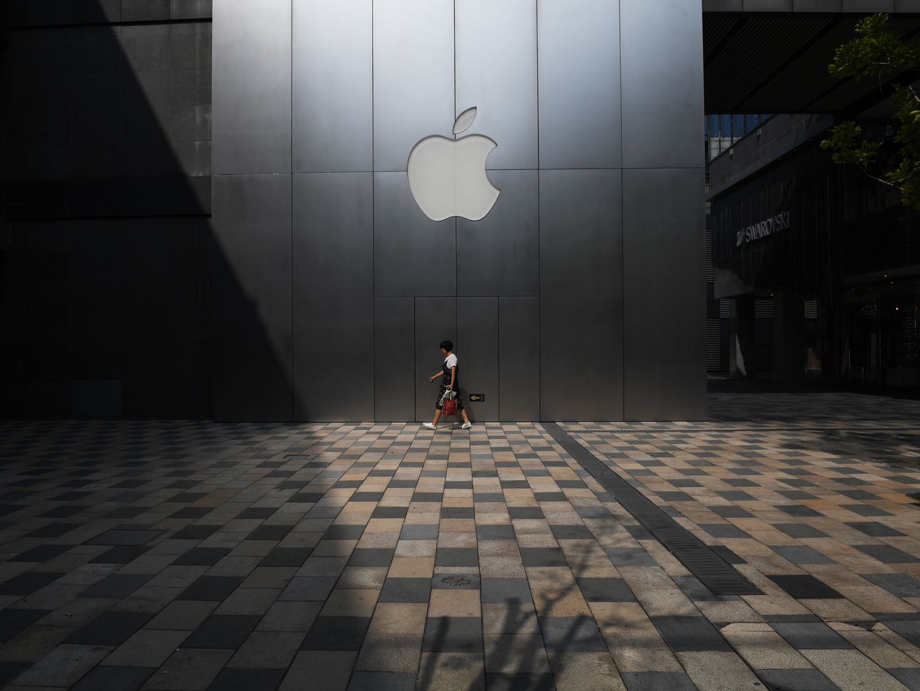 A woman walks past an Apple store in Beijing, China.