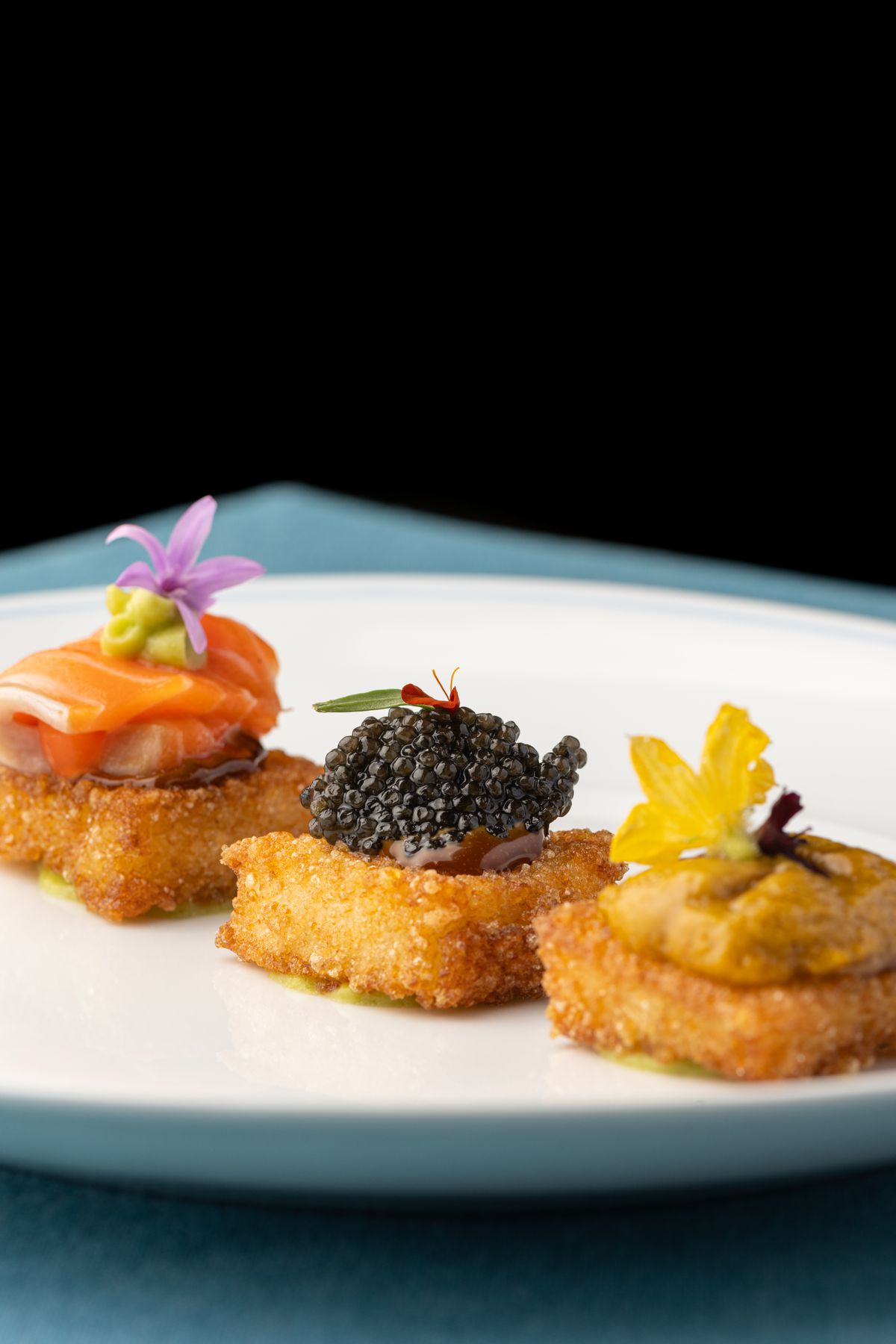 Torte di riso croccanti condite con caviale, uni e salmone al Caviar Kaspia.