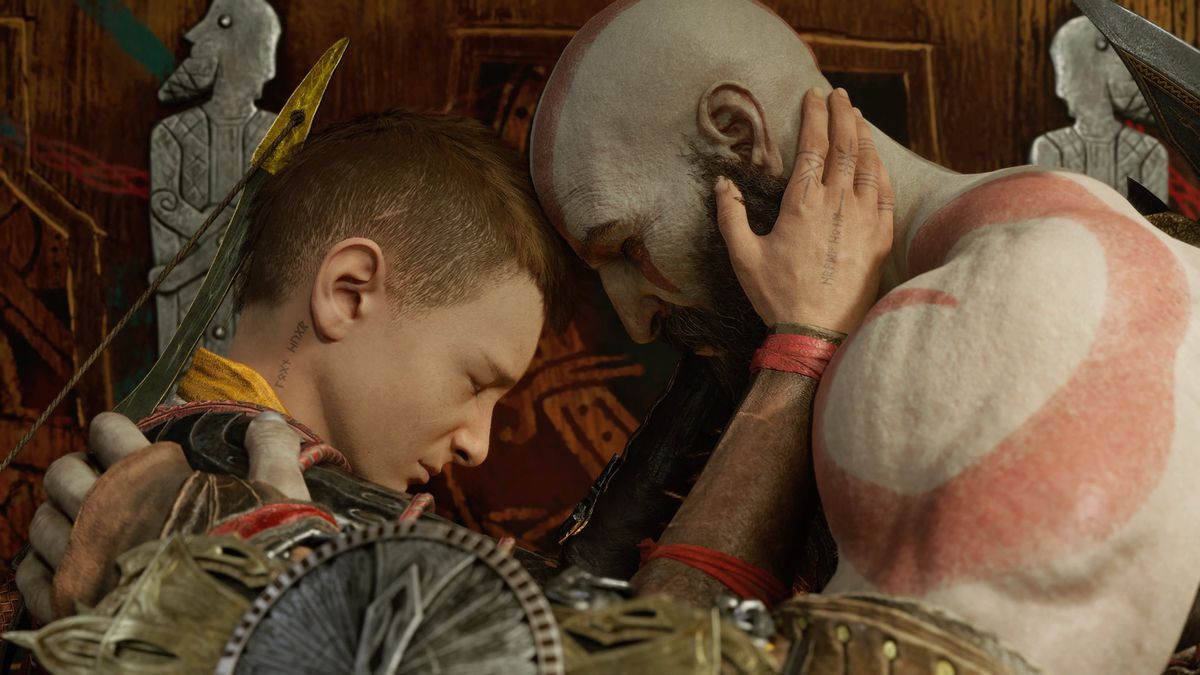 Kratos in Atreus se objemata in uživata v prijetnem trenutku ob koncu igre God of War Ragnarok.