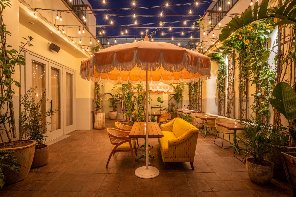 A bright yellow umbrella at a new restaurant patio at night, with lounge-y vibes.