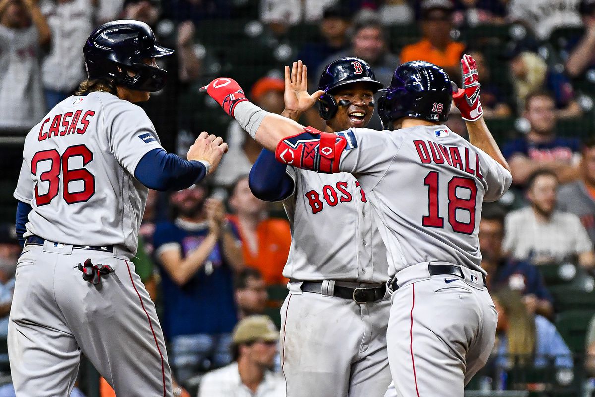 Adam Duvall of the Boston Red Sox celebrates with Triston Casas and Rafael Devers #11 after hitting a three-run home run in the ninth inning against the Houston Astros at Minute Maid Park on August 23, 2023 in Houston, Texas.