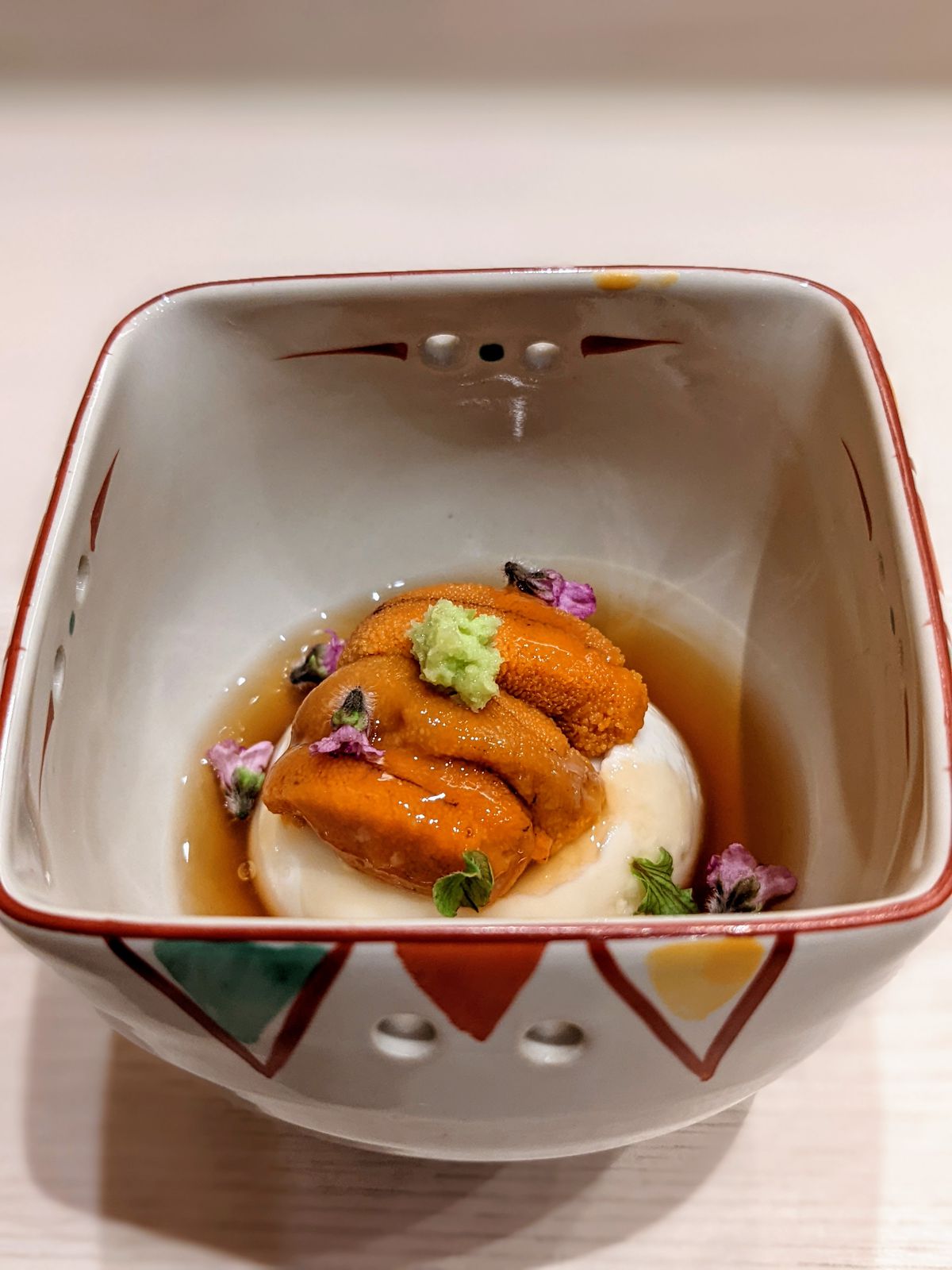 Fresh tofu topped with Hokkaido uni in a squared bowl.