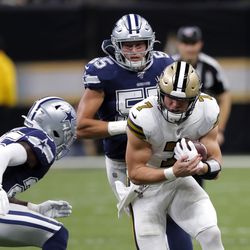 New Orleans Saints quarterback Taysom Hill (7) carries between Dallas Cowboys free safety Xavier Woods (25) and outside linebacker Leighton Vander Esch (55) in the first half of an NFL football game in New Orleans, Sunday, Sept. 29, 2019. 