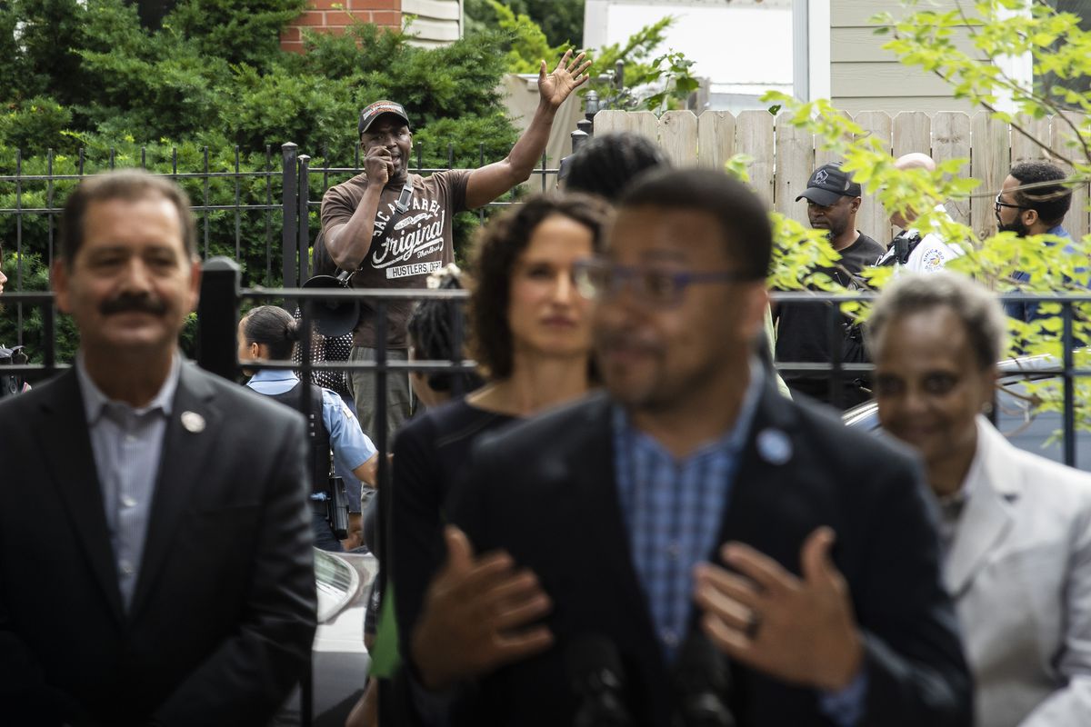 A protester speaks from the street outside as Ald. Michael Scott Jr. (24th) discusses the launch of the Reclaiming Communities Campaign during a news conference in North Lawndale on the Southwest Side, Monday, June 28, 2021.