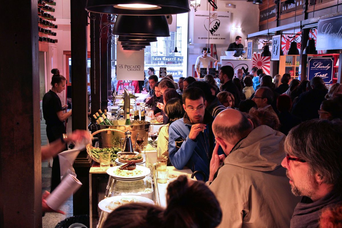 people crowded around a restaurant bar