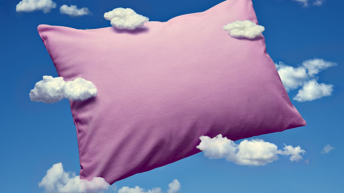 A pink pillow against a blue backdrop. White, airy clouds surround the pillow.