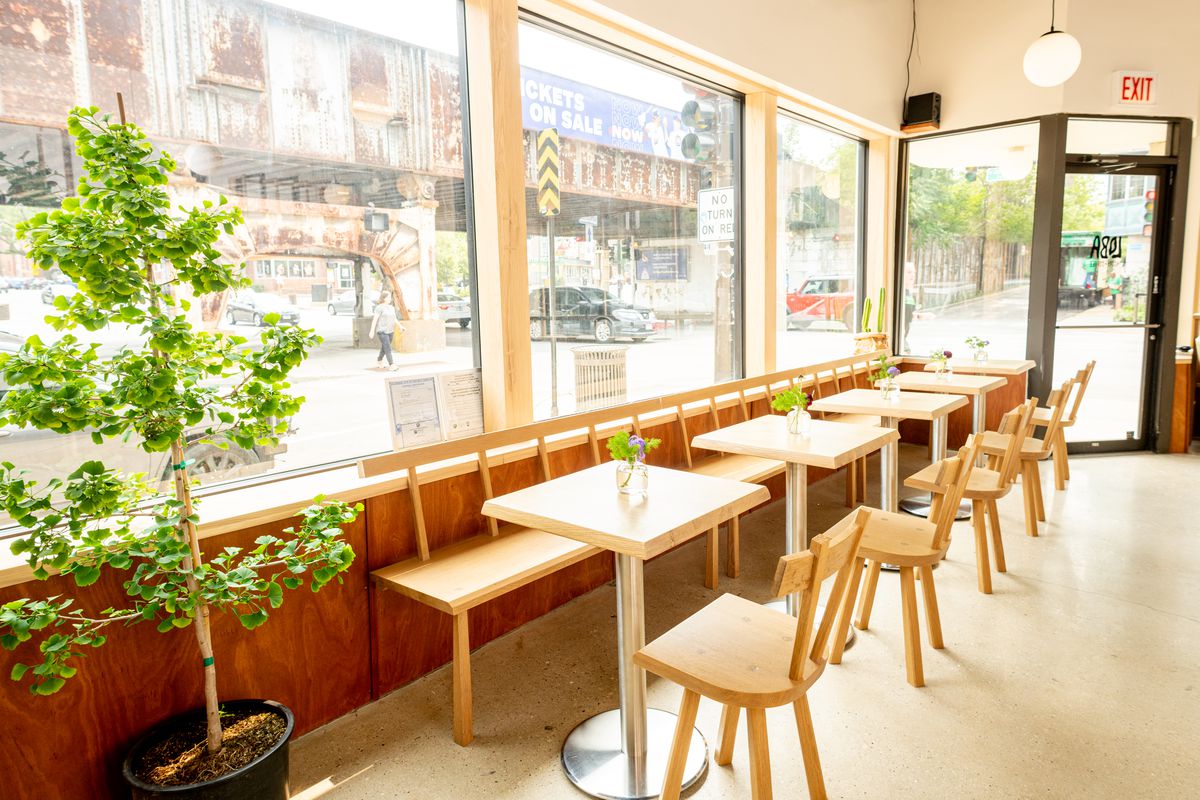 A row of tables along a window inside a cafe.