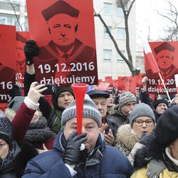 People raise placards showing the Head of the Constitutional Court Andrzej Rzeplinski, reading Thank You, as anti-government protesters gather in front of the Constitutional Court to thank for his efforts to defend the court's independence, in Warsaw, Poland, Sunday, Dec. 18, 2016.  