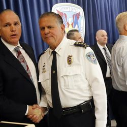 Jefferson Parish Sheriff Newell Normand shakes hands with Jefferson Parish coroner Gerry Cvitanovich, left, as he exits a press conference in Gretna, La., Tuesday, Dec. 6, 2016, where he announced the arrest of Ronald Gasser, in connection with the road rage shooting of former NFL player Joe McKnight. Gasser was arrested late Monday, Dec. 5, 2016, jailed on a charge of manslaughter. 