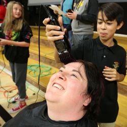 Science teacher Chelsey King gets her head shaved by eighth-grader Moises Vargas during the Penny Wars Assembly at Sunset Junior High in Sunset on Wednesday, Dec. 21, 2016. Students raised $8,300 in five days doing a penny wars competition between seventh-, eighth- and ninth-graders to help families who can't afford Christmas. One of the incentives was getting to watch all the science teachers shave their heads if they raised enough money.