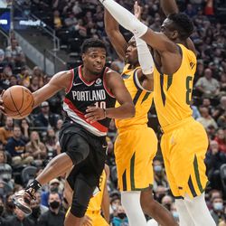 Portland Trail Blazers guard Dennis Smith Jr., left, looks to pass the ball against Utah Jazz during an NBA game at Vivint Arena in Salt Lake City on Monday, Nov. 29, 2021.