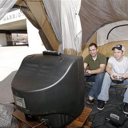 Y. students Brian Quigley, left, and Nick Wright play a video game inside a tent outside the Marriott Center Friday. 