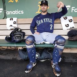 Catcher Tom Murphy #2 of the Seattle Mariners gives a thumbs down to a rain delay prior to playing the Oakland Athletics at RingCentral Coliseum on May 03, 2023 in Oakland, California.