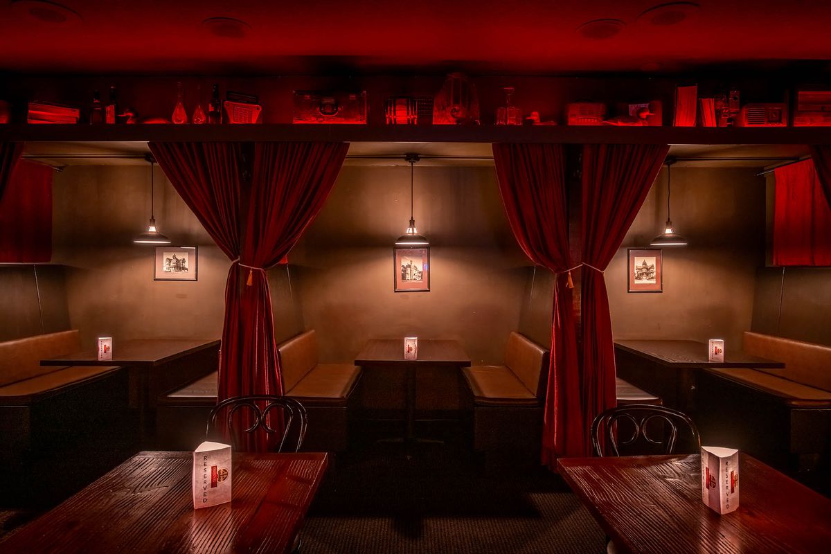 Velvet curtains and wooden booths and tables at the Rendition Room.