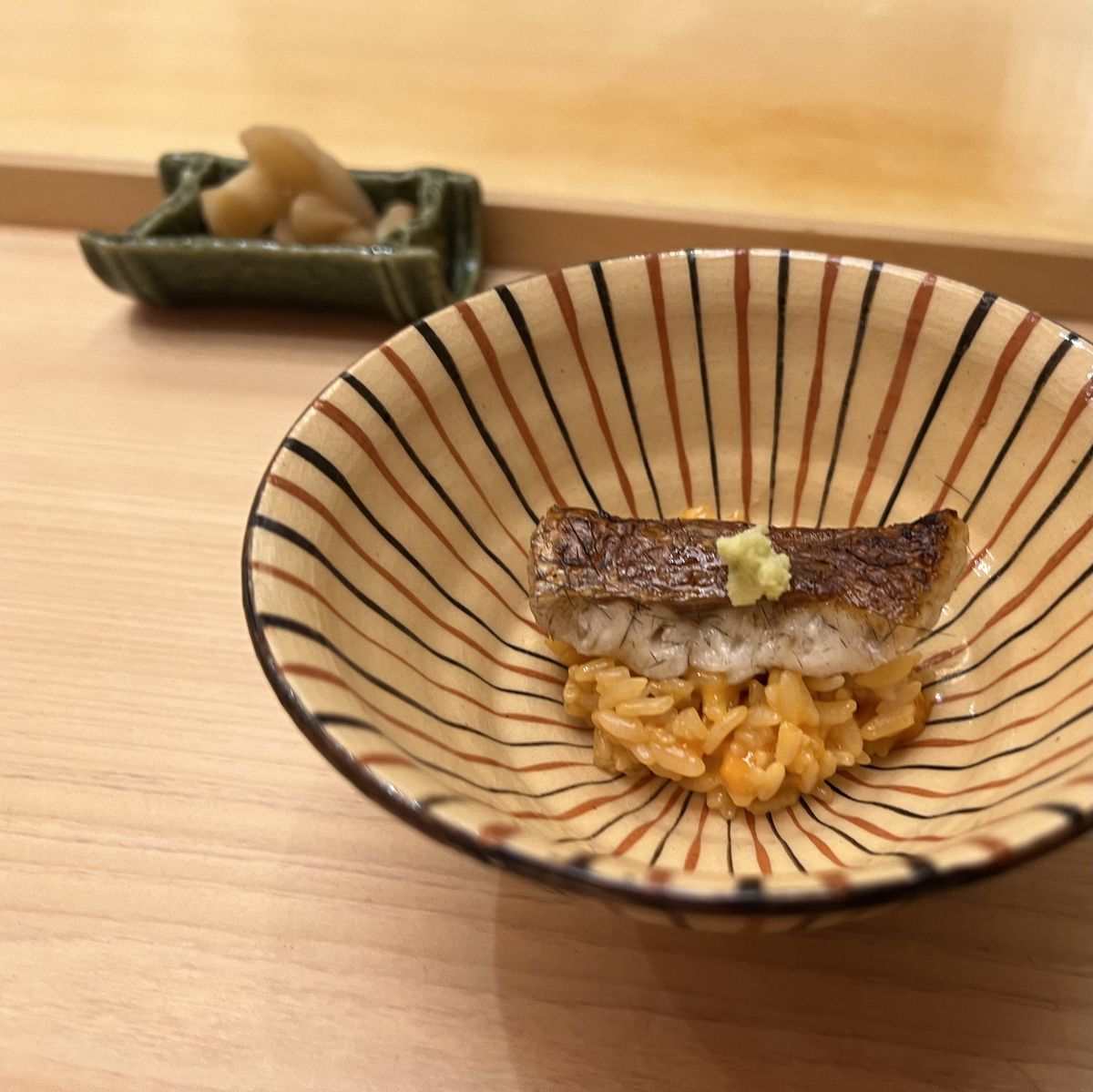 A filet of perch sits skin-side up over a mound of fresh uni rice.
