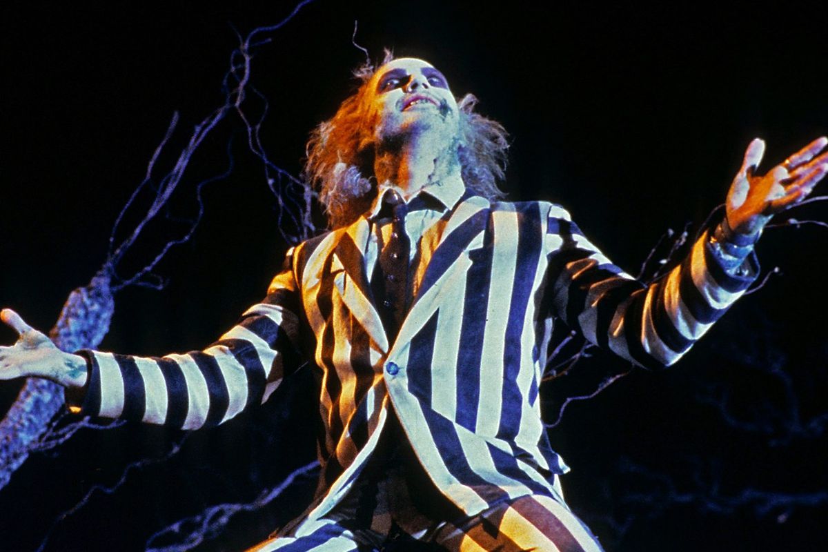 Michael Keaton as Beetlejuice with his arms outstretched
