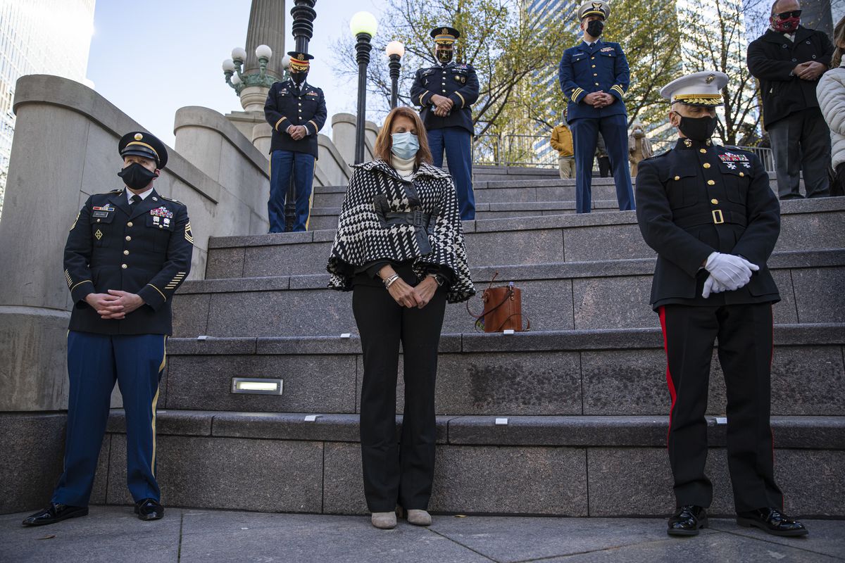 Attendees bow their heads in prayer during a Veterans Day ceremony on the Chicago Riverwalk in the Loop, Wednesday, Nov. 11, 2020. 