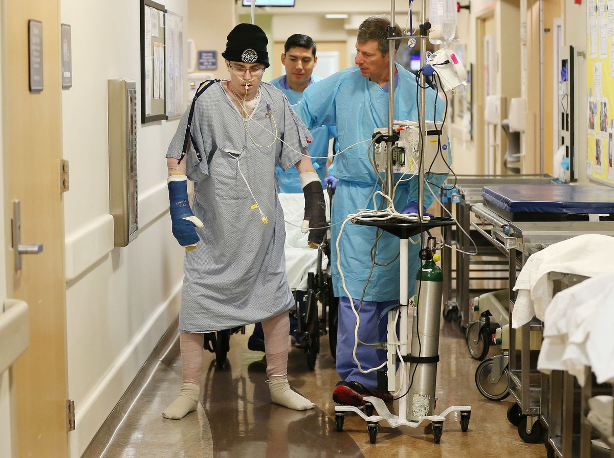 Physical therapist Walter Anyan walks with burn victim Austin Weaver during physical therapy at University of Utah Health's Burn Center in Salt Lake City on Friday, July 20, 2018. Weaver's family says his life has essentially been saved by a new burn trea