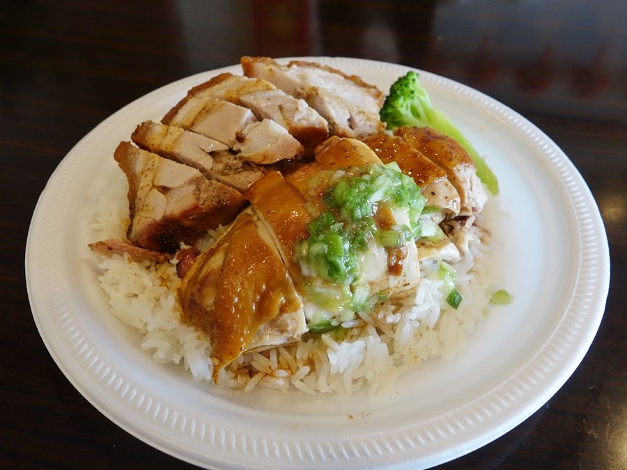A closeup of roasted pork with chicken on top of a  white plate.