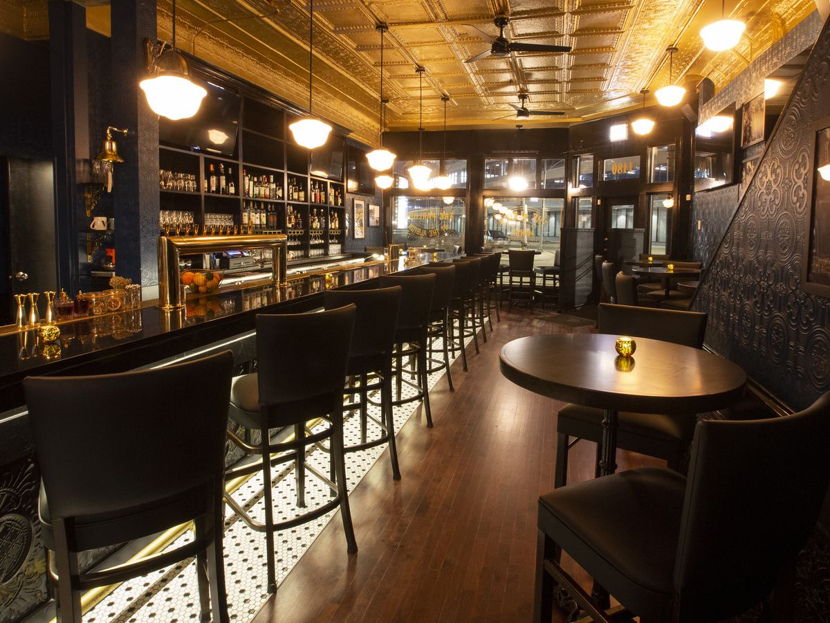 A long, narrow bar space with a pressed tin ceiling.