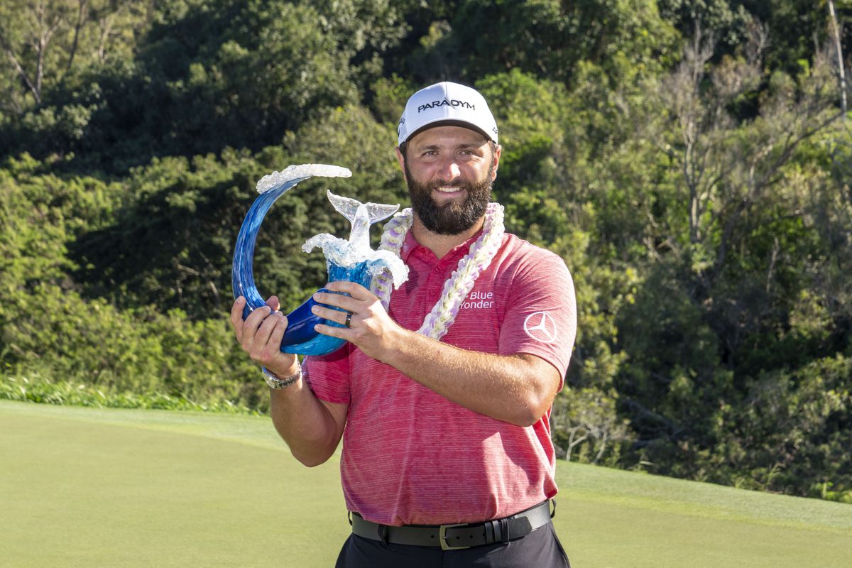 Jon Rahm hoists the trophy on the 18th hole during the final round of the Sentry Tournament of Champions golf tournament at Kapalua Resort.